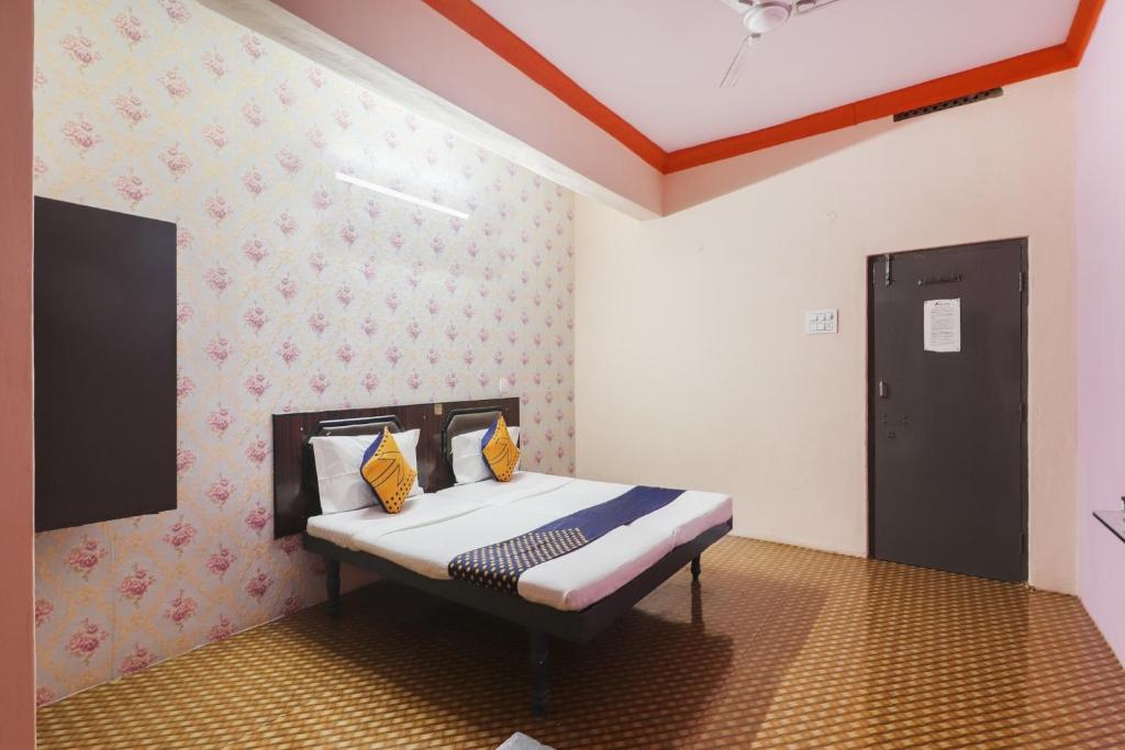 ハイデラバードにあるOYO Hotel 74966 Shree Amardeep Hotelのベッドルーム1室(黄色い枕のベッド1台付)