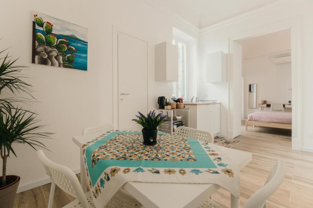 a white dining room with a table and chairs at Sofia's Central Apartment Palermo in Palermo