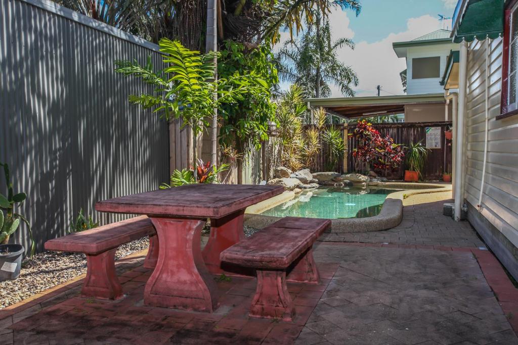 a picnic table and bench next to a swimming pool at Ryan's Rest Boutique Accommodation in Cairns