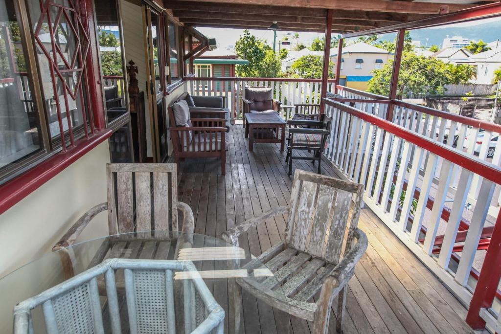 a porch with chairs and tables on a balcony at Ryan's Rest Boutique Accommodation in Cairns