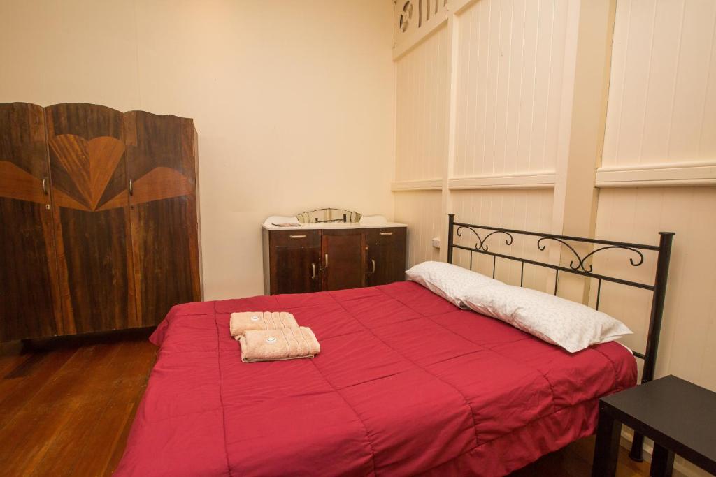 a bedroom with a red bed with two towels on it at Ryan's Rest Boutique Accommodation in Cairns