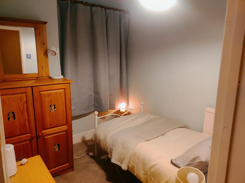 a small bedroom with a bed and a dresser at Cosy London single room (near Wimbledon) in London