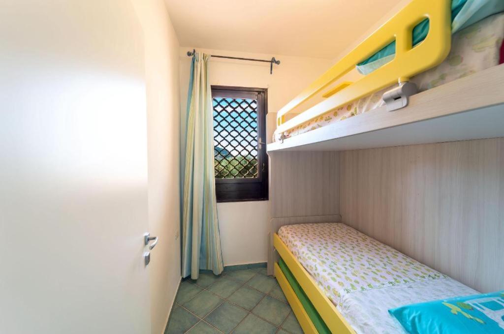 ein kleines Schlafzimmer mit einem Etagenbett und einem Fenster in der Unterkunft Pelosa - Capo Falcone Excellent Apartment in Stintino