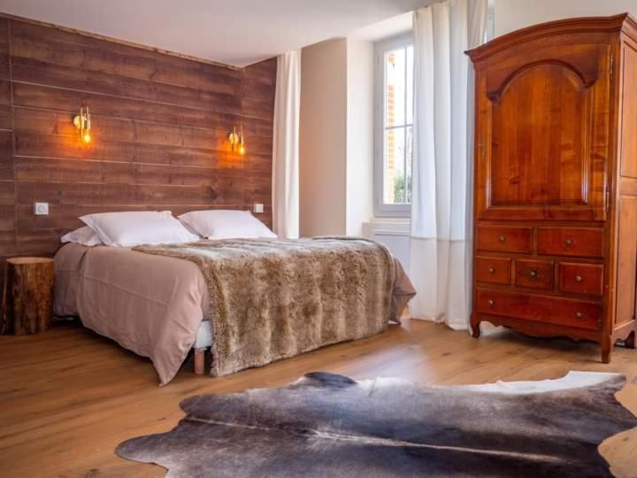 a bedroom with a large bed and a dresser at Le RELAIS DE LEZAT in Lézat-sur-Lèze
