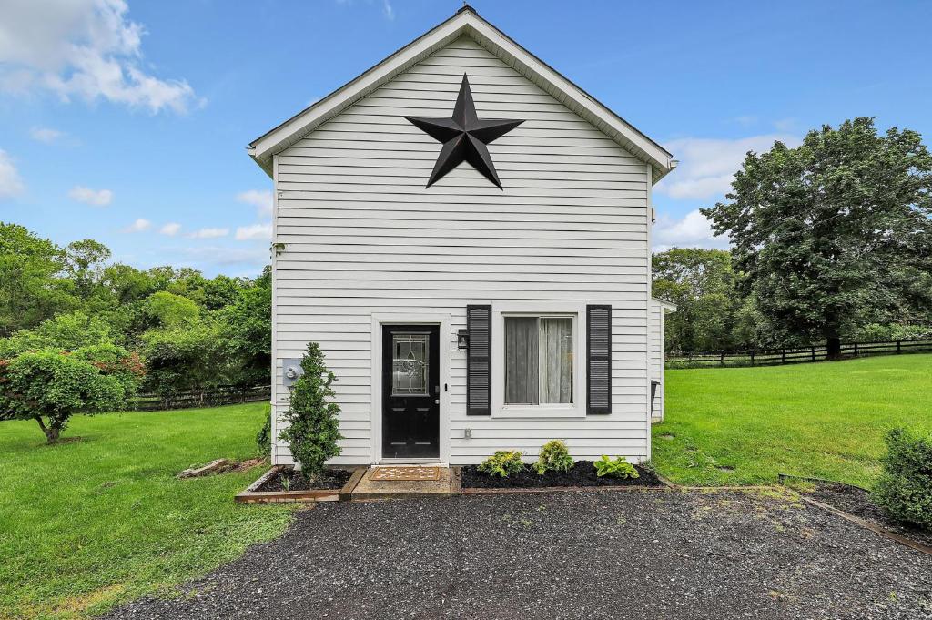 Lovettsville的住宿－Cottage Escape in Virginia Wine Country，屋顶上有一颗大星的白色房子