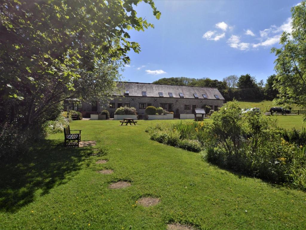 a large building with a grassy yard with a bench at 1 Bed in Lyme Regis 90145 in Lyme Regis