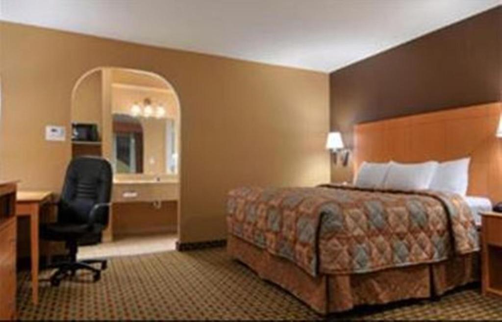 a hotel room with a bed and a desk at Days Inn by Wyndham Lubbock South in Lubbock