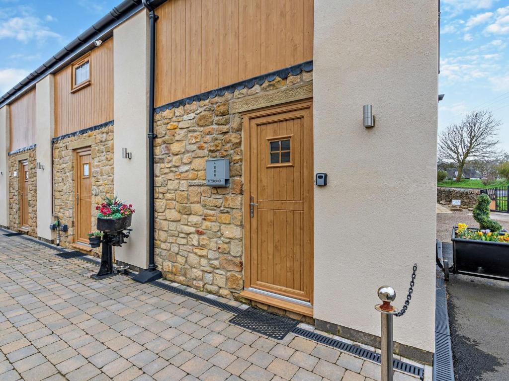 a building with a wooden door and some flowers at 3 Bed in Durham 94762 in Lanchester