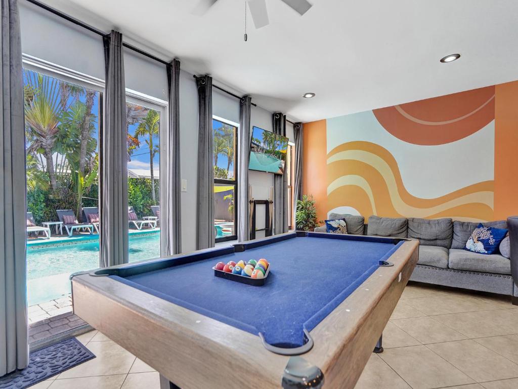 una mesa de billar en una sala de estar junto a una piscina en Large GAY MEN'S 1 bedroom w Gameroom heated pool clothing optional, en Fort Lauderdale