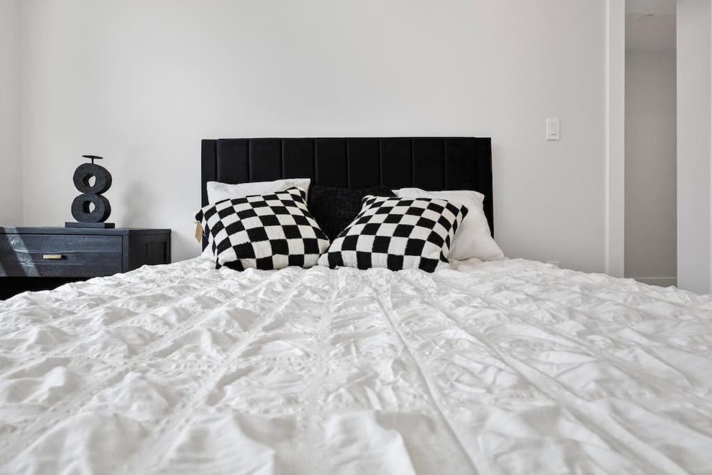a white bed with black and white pillows on it at 3BR2Bth parking Cambridge Boston in Somerville