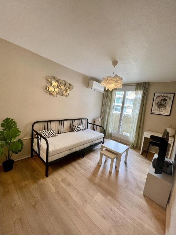 une chambre avec un lit, une table et une fenêtre dans l'établissement Joli studio niçois proche mer, à Nice