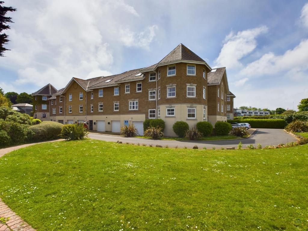 a large brick building with a green lawn at 12A Solent Landing direct beach access in Bembridge