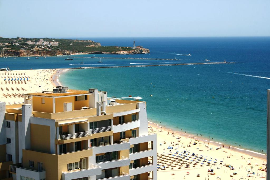 a view of a beach and a building at DOM ELENA - JARDINS DA ROCHA in Portimão