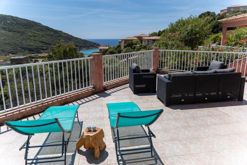 2 blaue Stühle und ein Tisch auf einer Terrasse in der Unterkunft Villa Tizzano Vue Mer in Sartène