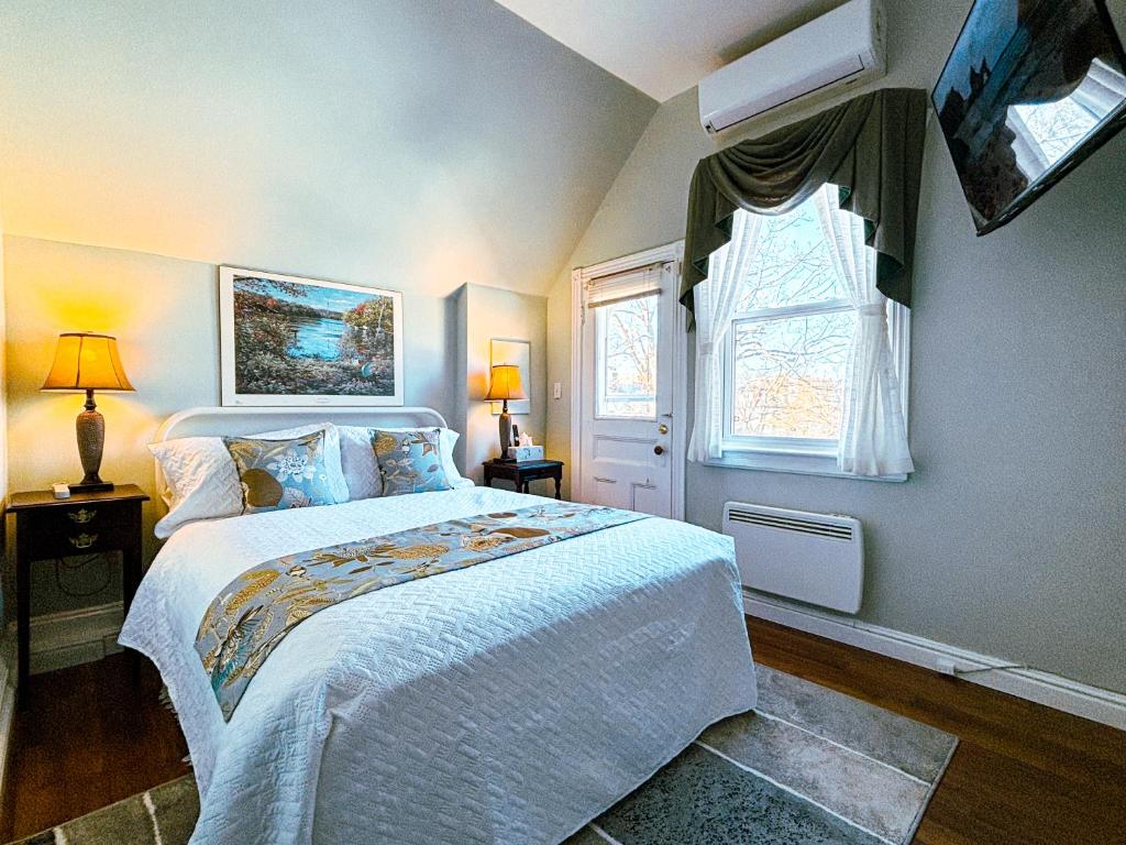 a bedroom with a white bed and a window at The Eden Hall Inn in Charlottetown