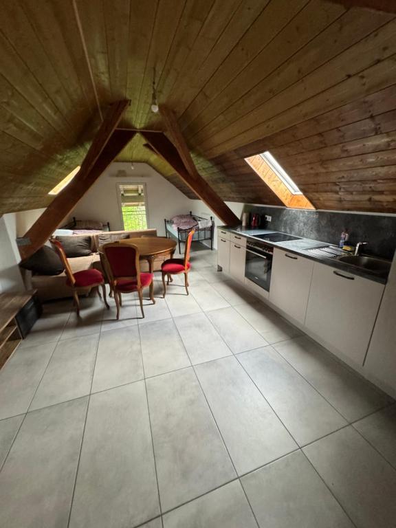 a kitchen with a table and chairs and a wooden ceiling at Mira Home 3 in Murg
