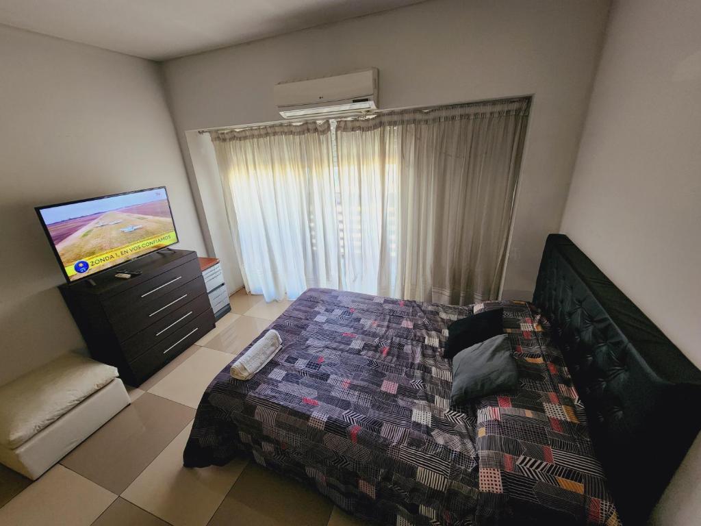 a bedroom with a bed and a flat screen tv at departamento céntrico corrientes y callao!!! in Buenos Aires