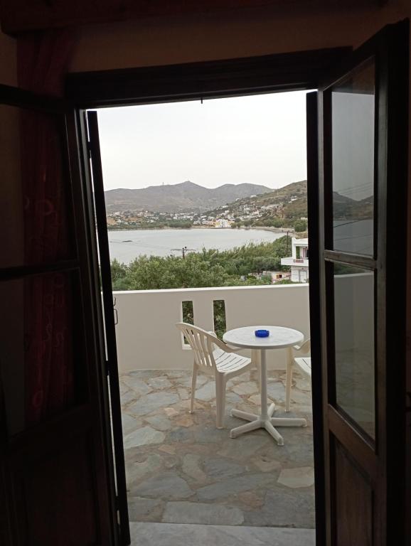 una mesa y una silla en un balcón con vistas en Akrogiali Rooms & Studios, en Drymonas