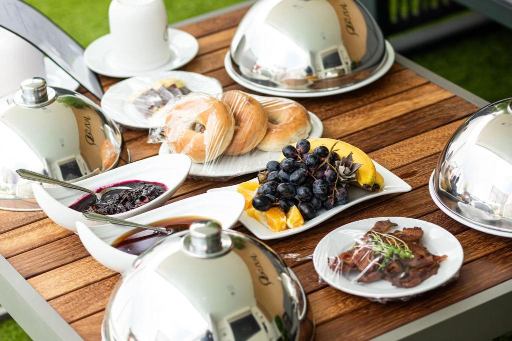 a wooden table topped with plates of food and teapots at Jazuri Villa in Buccoo