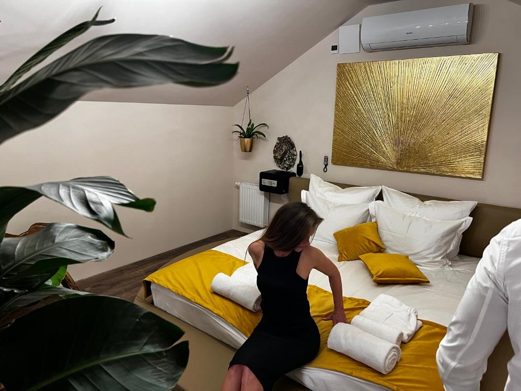 kobieta w czarnej sukience stojąca na łóżku w obiekcie JUNGLE Wellness Apartment w mieście Trzin