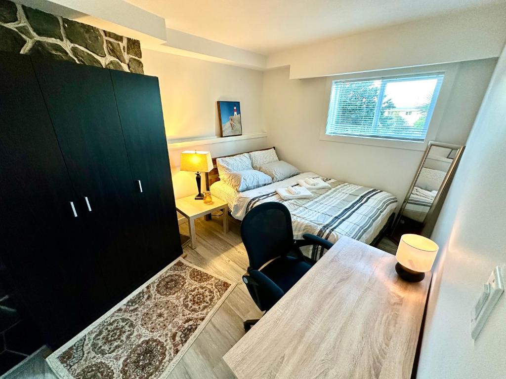 a small room with a bed and a table in it at Modern Cozy Home W Free Parking- Close to Downtown & Beach in Victoria