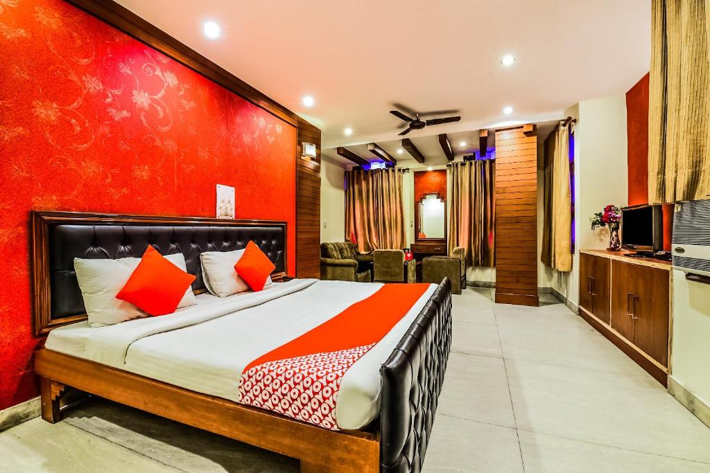 a bedroom with a bed with a red wall at Super OYO Hotel City Castle in New Delhi