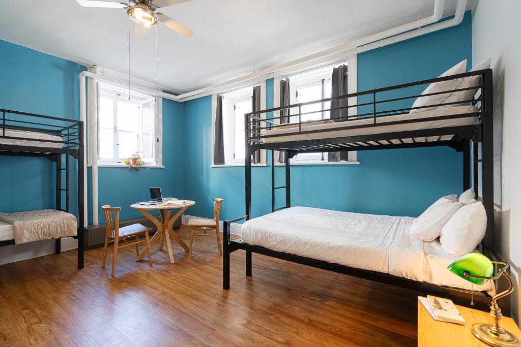 1 Schlafzimmer mit 2 Etagenbetten und einem Tisch in der Unterkunft Auberge Internationale de Quebec - HI CANADA in Québec