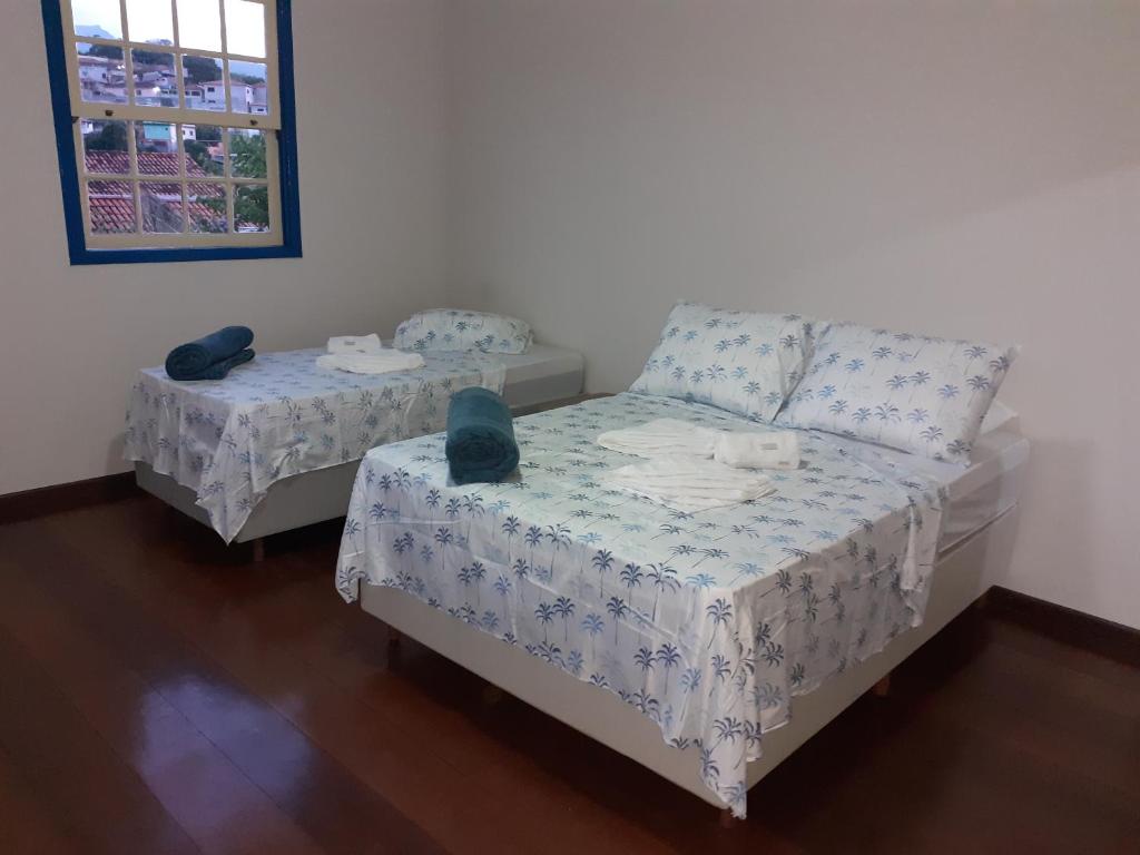 马里亚纳Quarto Casal Simples的一间卧室设有两张床、一张床和窗户。