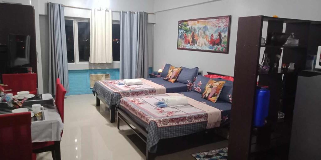 uma sala de estar com duas camas e um sofá em CP19P TWINBED COZY ROOM Near at Venice Mall em Manila