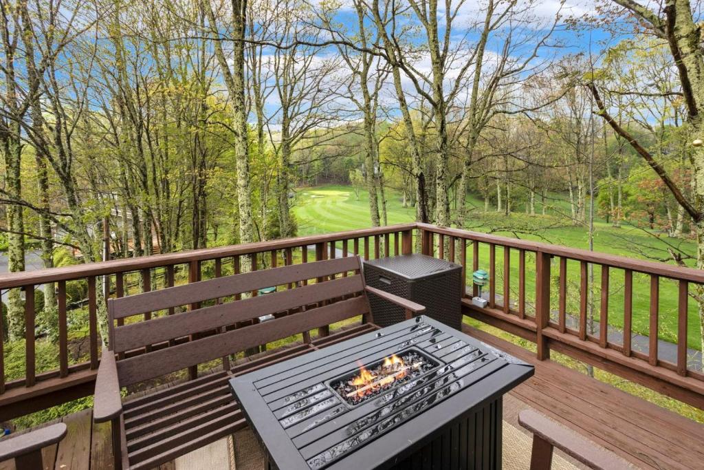a grill sitting on a wooden bench on a deck at Fairway to Heaven on Beech in Beech Mountain