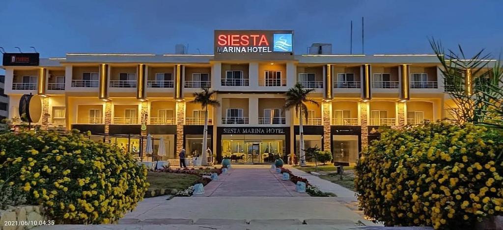New Siesta M Hotel في العلمين: مبنى عليه لافته مكتوب عليها قصر القيلوله