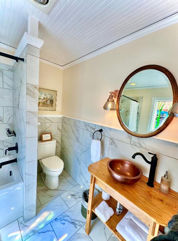 a bathroom with a sink and a toilet and a mirror at Orcas Hotel in Orcas