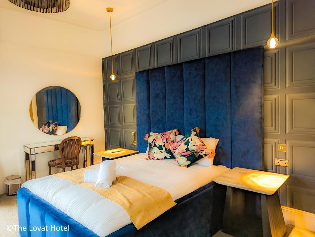 a bedroom with a large bed with a blue wall at The Lovat Hotel in Perth