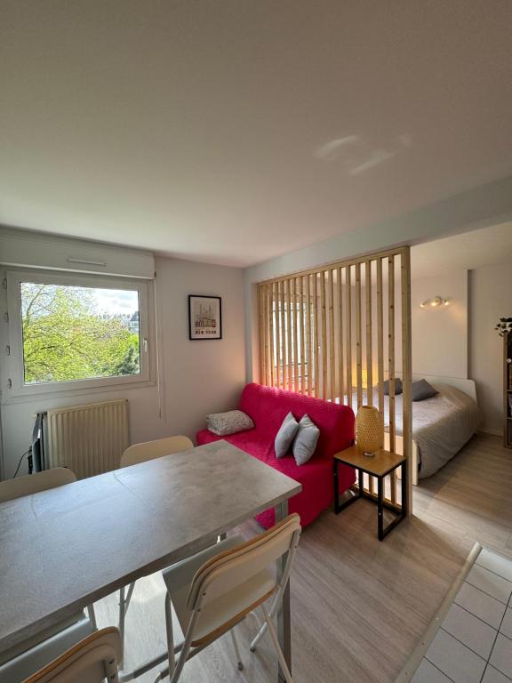 - un salon avec un canapé rouge et un lit dans l'établissement Vauban T1 calme avec parking privatif, à Lille