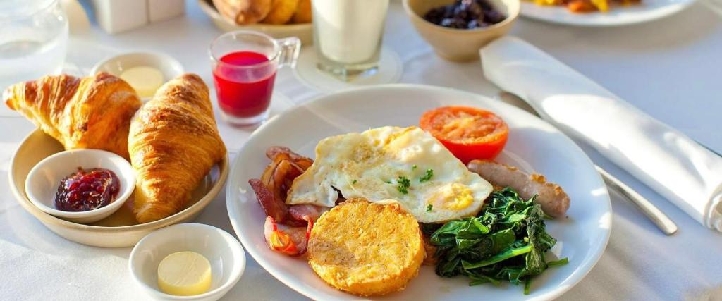 - une assiette blanche de nourriture pour le petit-déjeuner sur une table dans l'établissement Five Hotel, à Astana