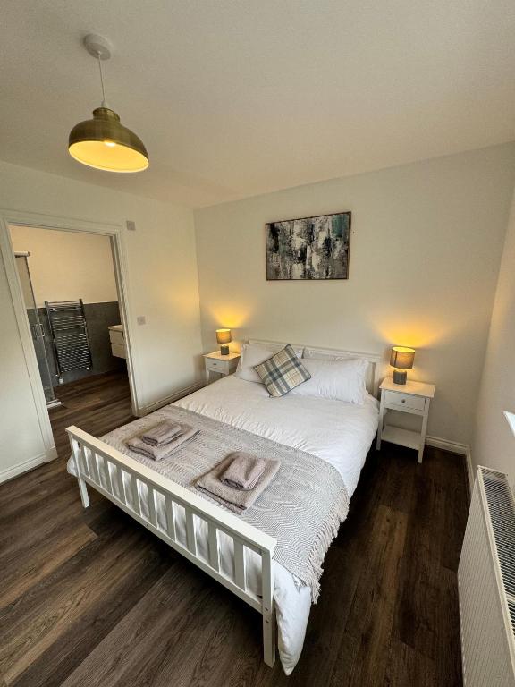 a bedroom with a large bed with two night stands at Inchfad Apartment 2/1 in Bonhill