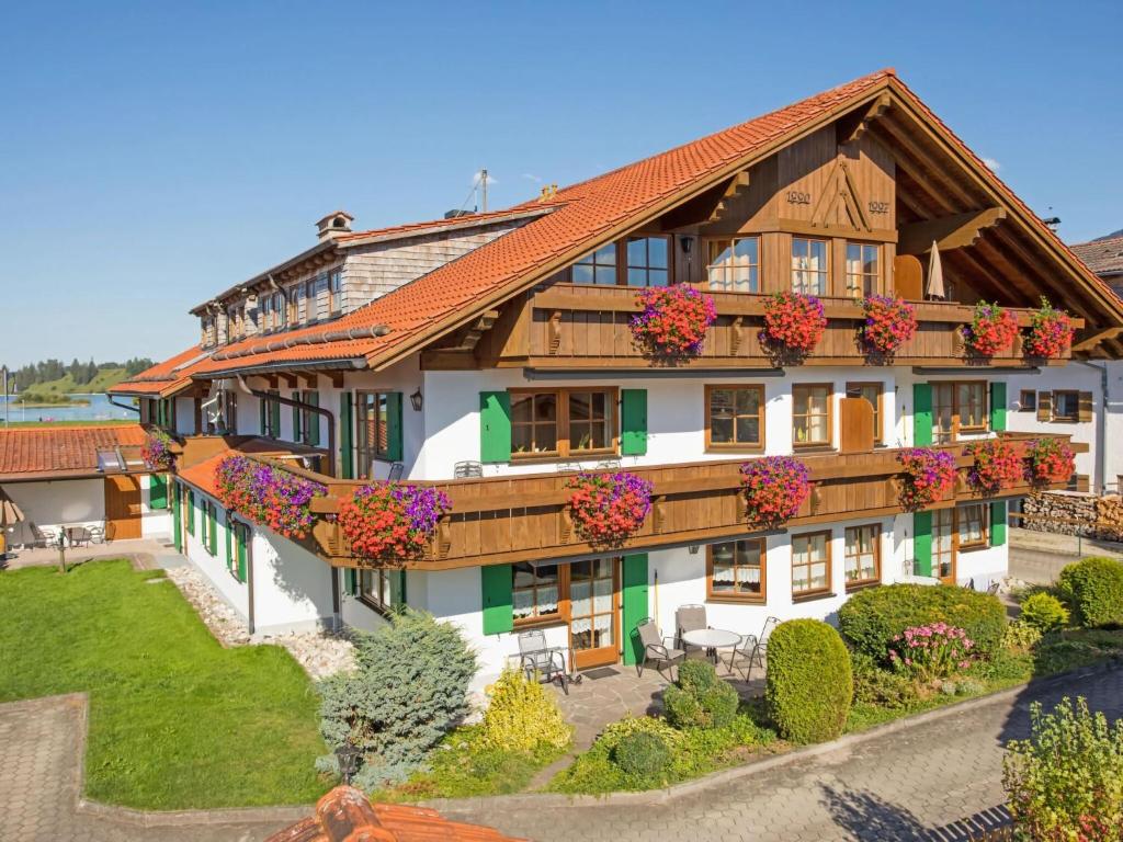 una casa grande con flores en el patio en Holiday home for a family getaway, en Schwangau