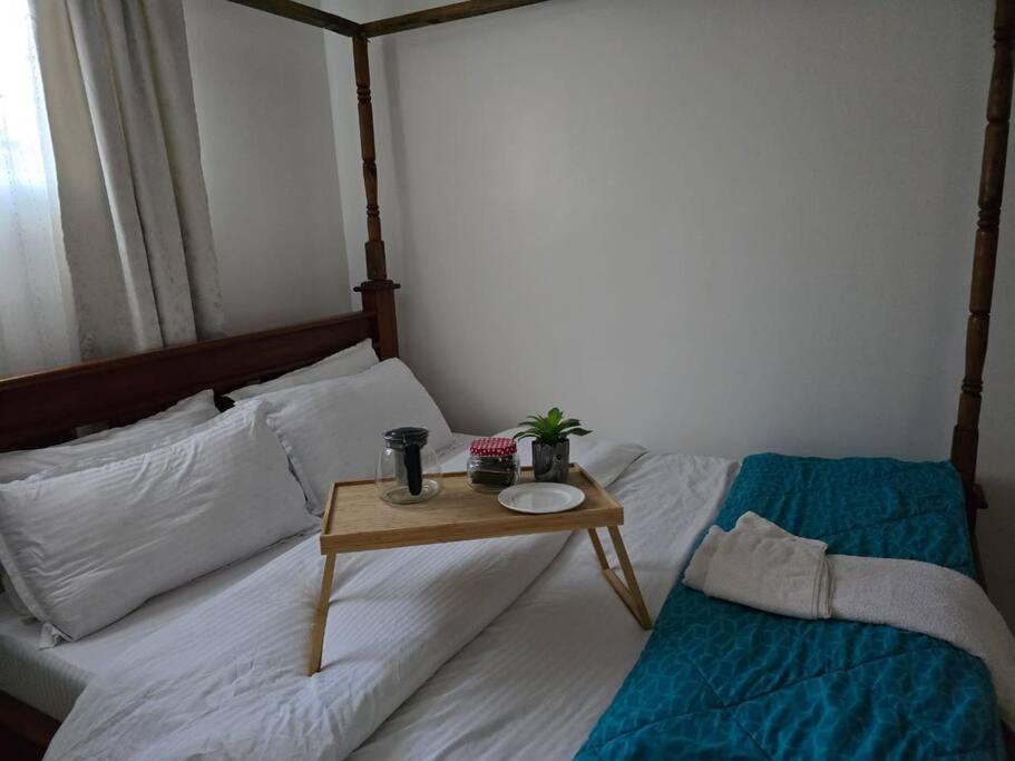 una camera da letto con un letto e un tavolo sopra di Masons Tiny Cottage a Nairobi