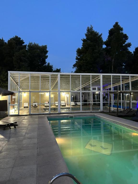 un gran edificio con piscina por la noche en Las Lomas Suites & Spa en Chascomús
