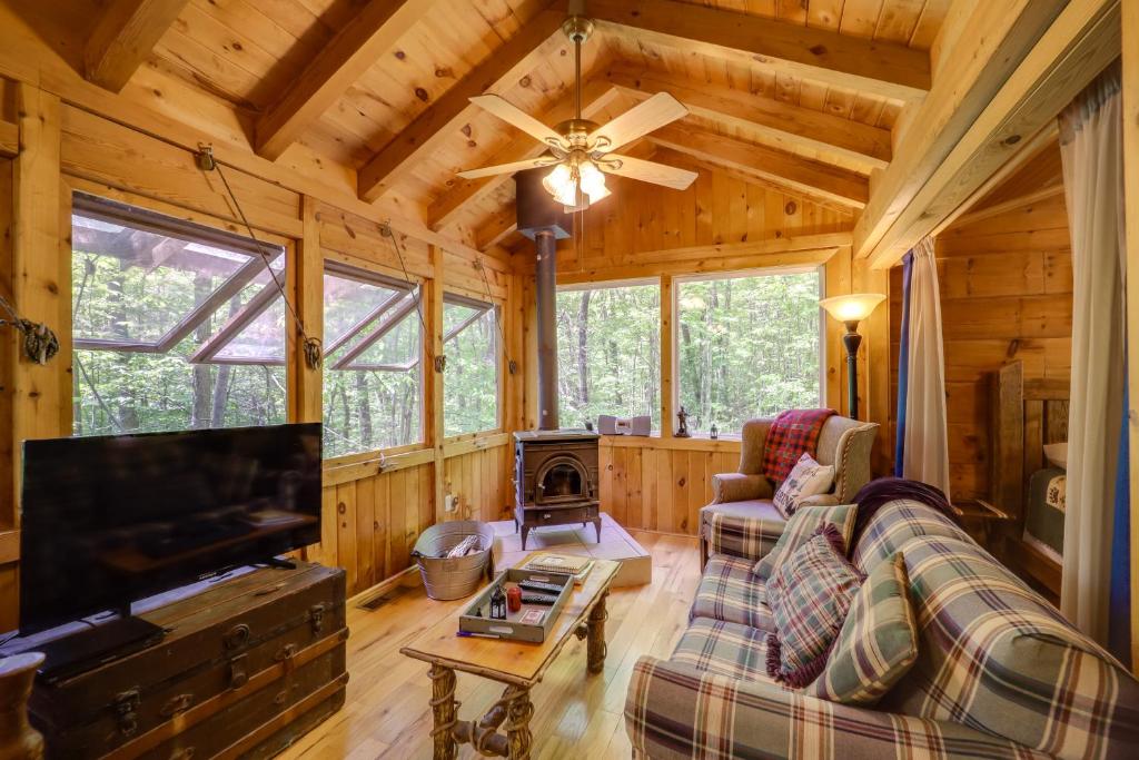 a living room with a couch and a television in a cabin at Hike, Soak and Unwind in Nature Blue Ridge Cabin in Marion