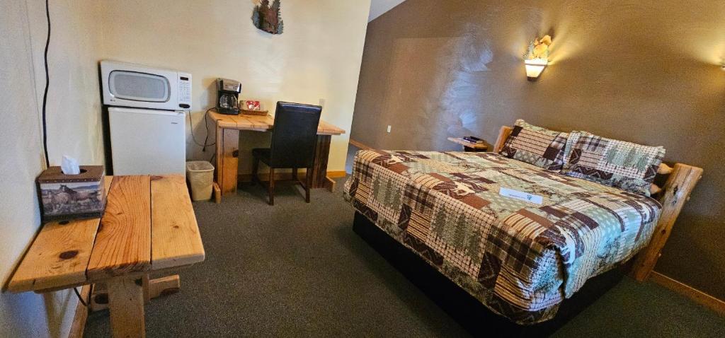 a bedroom with a bed and a table and a desk at Nine Pines Motel in Pinetop-Lakeside