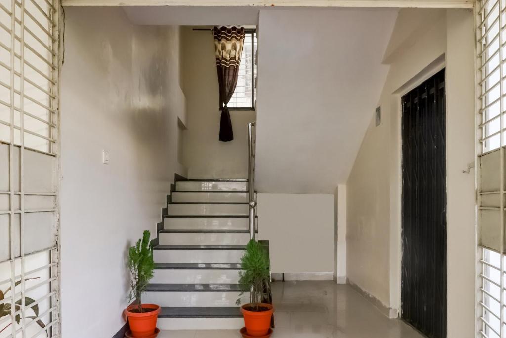 a hallway with stairs and potted plants at OYO SHRIDHAR CREATIVE Hotel & Restaurant in Nagpur