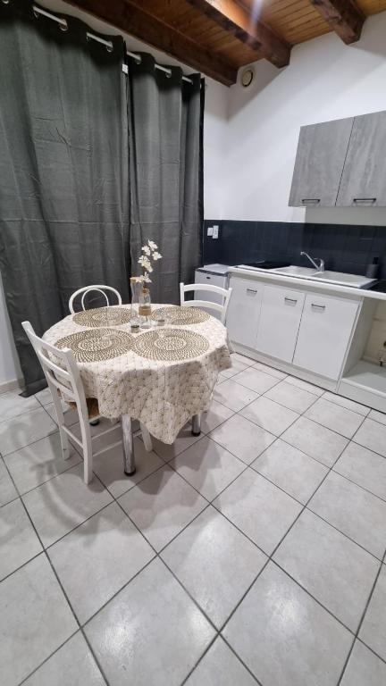 une cuisine avec une table et des chaises dans une pièce dans l'établissement Gite du soleil levant jura, à Gevingey