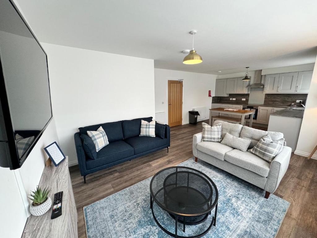 una sala de estar con un sofá y una mesa en Inchmoan Apartment, en Bonhill
