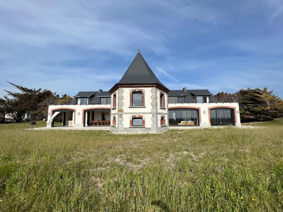une grande maison avec un toit noir dans un champ dans l'établissement Le Sémaphore, à Saint-Germain-sur-Ay