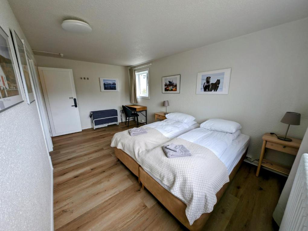 1 dormitorio con 1 cama grande con sábanas blancas en The Stykkishólmur Inn, en Stykkishólmur