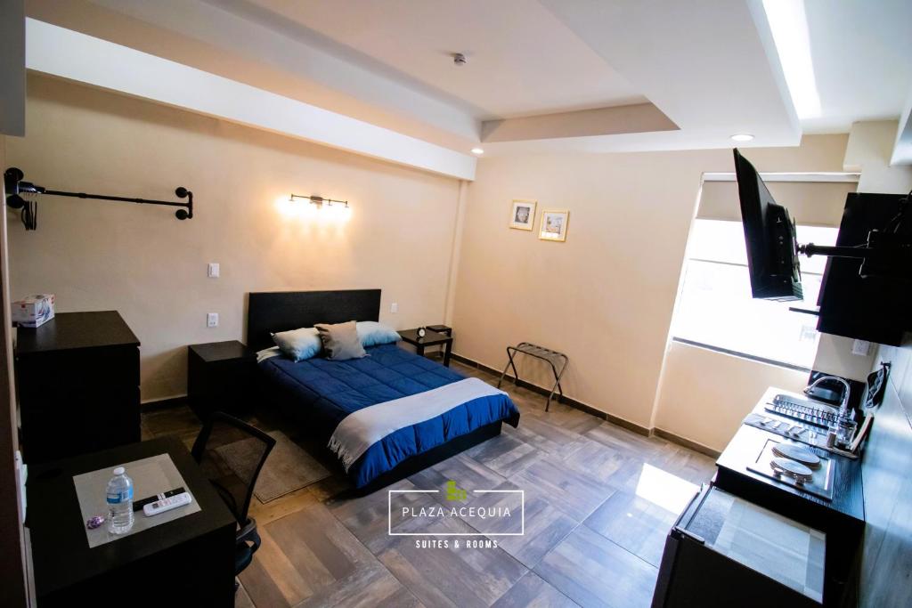 um quarto com uma cama, uma secretária e uma televisão em A02 Full Suite ‖ Mini Dept at Plaza Acequia em Cuautitlán Izcalli