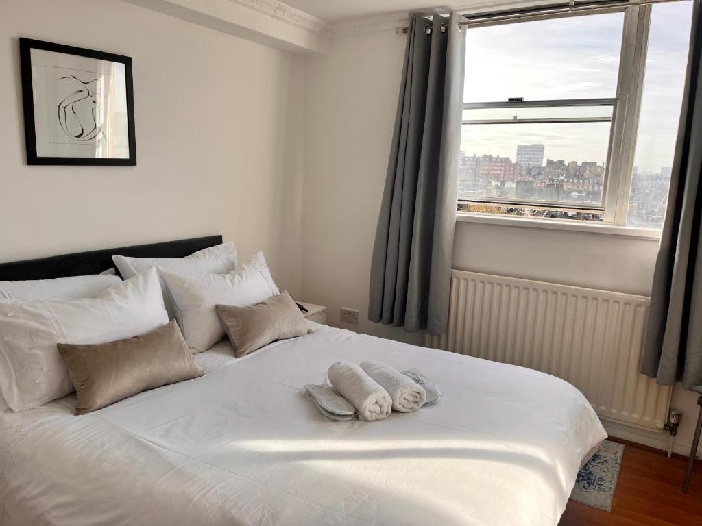 a bedroom with a white bed with two towels on it at Hyde Park,3 min walk,Family home! 2 Bedrooms & 2 Bathrooms Apartment! Fantastic Location in London