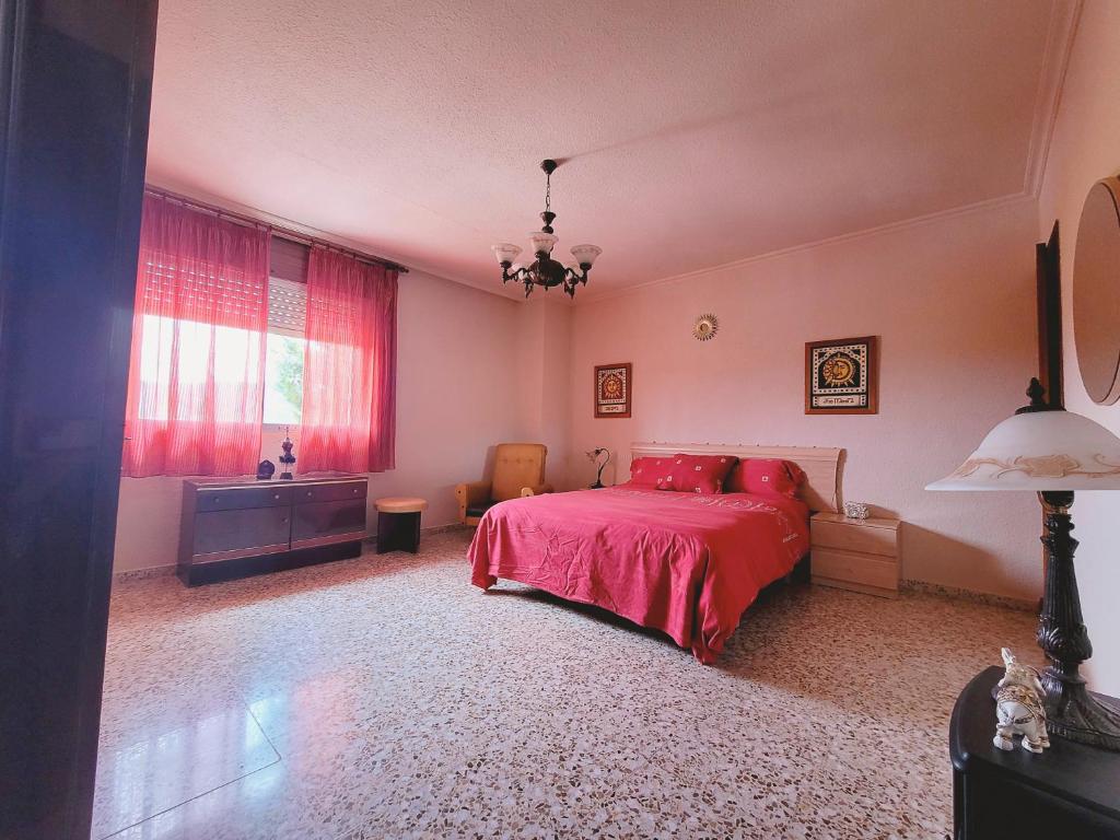 Casa Verna Jacuzzi y Barbacoa في مورسية: غرفة نوم بسرير احمر ونافذة