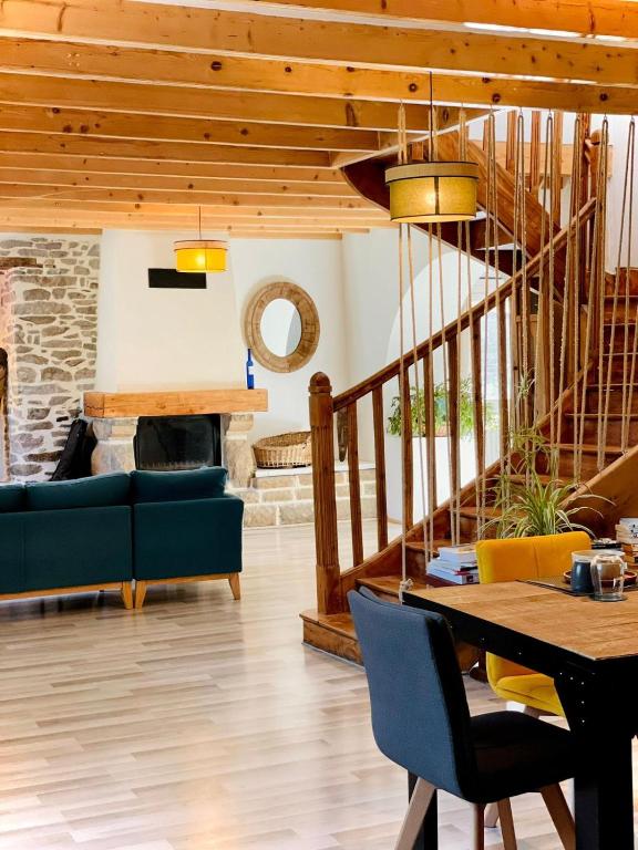 a living room with a staircase and a table and chairs at Le Bercail in Plouézec